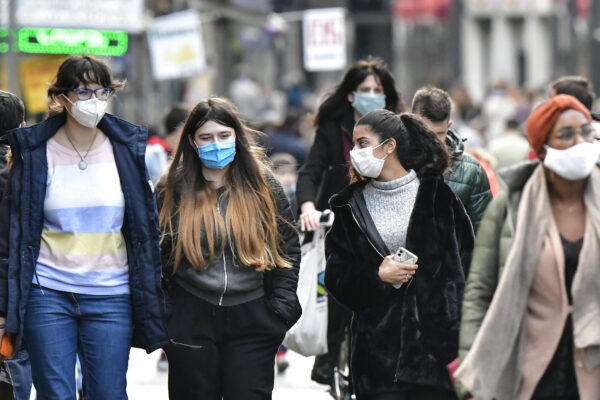 People walk with face masks to protect against coronavirus, in Cologne, Germany, Sunday, Oct. 11, 2020. Germany’s 4th largest city reported exceeding the important warning level of 50 new infections per 100,000 inhabitants in seven days. More and more German cities become official high risk corona hotspots with travel restrictions within Germany. (AP Photo/Martin Meissner)