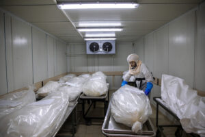 A worker from "Hevra Kadisha," Israel’s official Jewish burial society, prepares bodies before a funeral procession at a special morgue for COVID-19 victims, during a nationwide lockdown to curb the spread of the coronavirus, in the central Israeli city of Holon, near Tel Aviv, Monday, Oct. 12, 2020. (AP Photo/Oded Balilty)