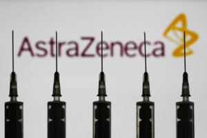 Medical syringes are seen with AstraZeneca company logo displayed on a screen in the background in this illustration photo taken in Poland on October 12, 2020. (Photo illustration by Jakub Porzycki/NurPhoto via Getty Images)