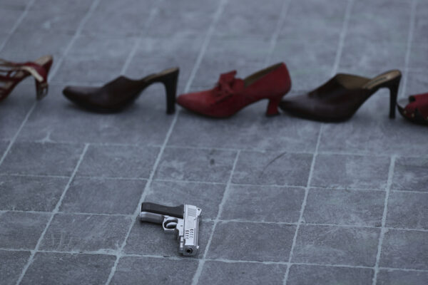 A toy gun is placed near a line of red shoes representing murdered women, as part of a performance during the national women’s strike "A Day Without Women" in Mexico City, Monday, March 9, 2020. Thousands of women across Mexico went on strike after an unprecedented number of girls and women hit the streets to protest rampant gender violence on International Women’s Day. (AP Photo/Fernando Llano)