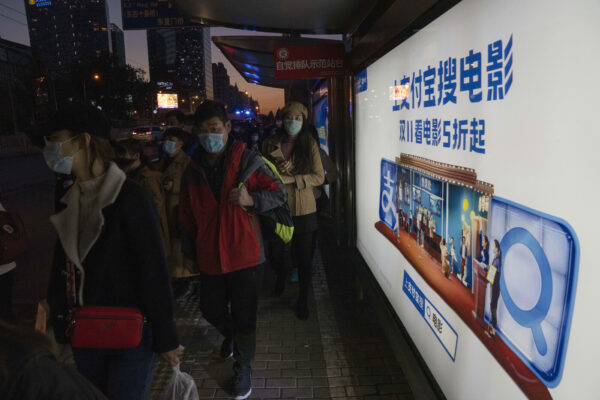 Residents wearing masks to protect from the coronavirus pass by an ad promoting 50% for online movies during the Nov. 11 Sales Day, in Beijing on Sunday, Nov. 8, 2020. Chinese consumers are expected to spend tens of billions on everything from fresh food to luxury goods during this year’s Singles’ Day online shopping festival, as the country recovers from the coronavirus pandemic. (AP Photo/Ng Han Guan) Residents wearing masks to protect from the coronavirus pass by an ad promoting 50% for online movies during the Nov. 11 Sales Day, in Beijing on Sunday, Nov. 8, 2020. Chinese consumers are expected to spend tens of billions on everything from fresh food to luxury goods during this year’s Singles’ Day online shopping festival, as the country recovers from the coronavirus pandemic. (AP Photo/Ng Han Guan)