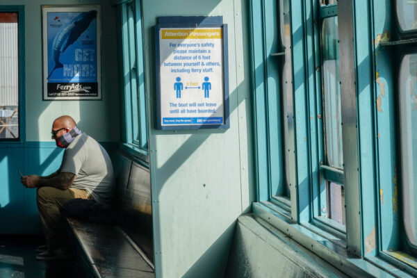 A commuter rides the Staten Island ferry with a mask partially covering his face, Tuesday, Nov. 10, 2020, in New York. New York City officials are raising awareness and its efforts in stemming a rise in COVID-19 on Staten Island. (AP Photo/Mary Altaffer)