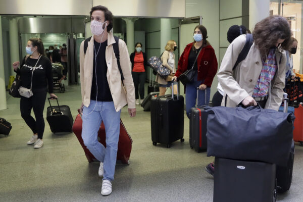 Travellers arrive from a Eurostar train at St Pancras Station in London, Friday, Aug. 14, 2020. People arriving in UK from France, the Netherlands, Monaco, Malta, Turks & Caicos and Aruba from 04:00 Saturday Aug.15 will need to self-isolate for two weeks as these countries are removed from the travel exemptions list. (AP Photo/Kirsty Wigglesworth)