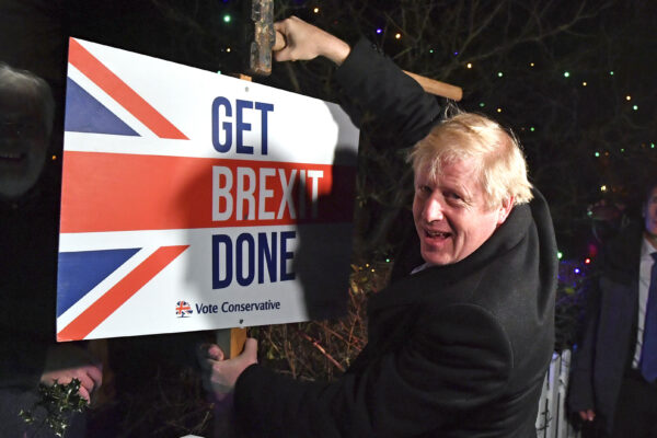 FILE — In this Wednesday, Dec. 11, 2019 file photo, Britain’s Prime Minister and Conservative party leader Boris Johnson poses as he hammers a "Get Brexit Done" sign into the garden of a supporter, in Benfleet, England. Britain and the European Union have struck a provisional free-trade agreement that should avert New Year chaos for cross-border traders and bring a measure of certainty for businesses after years of Brexit turmoil.  (Ben Stansall/Pool via AP, File)