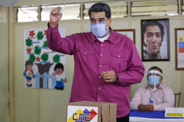 Venezuela’s President Nicolas Maduro shows his ballot during elections to choose members of the National Assembly in Caracas, Venezuela, Sunday, Dec. 6, 2020. The vote, championed by Maduro, is rejected as fraud by the nation’s most influential opposition politicians. (AP Photo/Ariana Cubillos)