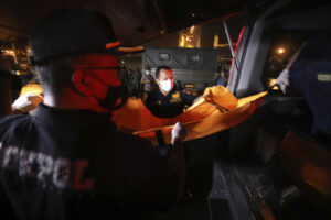Members of police forensic team load a body bag containing debris found in the waters where a Sriwijaya Air passenger jet has lost contact with air traffic controllers shortly after take off, into an ambulance at Tanjung Priok Port in Jakarta, Indonesia, early Sunday, Jan. 10, 2021.  The Boeing 737-500 took off from Jakarta for Pontianak, the capital of West Kalimantan province on Indonesia’s Borneo island,  with 56 passengers and six crew members onboard, and lost contact with the control tower a few moments later. (AP Photo/Dita Alangkara)
