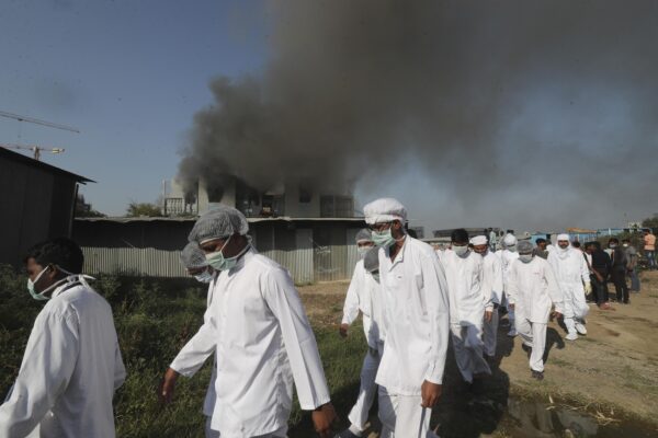 Employees leave as smoke rises from a fire at Serum Institute of India, the world’s largest vaccine maker that is manufacturing the AstraZeneca/Oxford University vaccine for the coronavirus, in Pune, India, Thursday, Jan. 21, 2021. (AP Photo/Rafiq Maqbool)