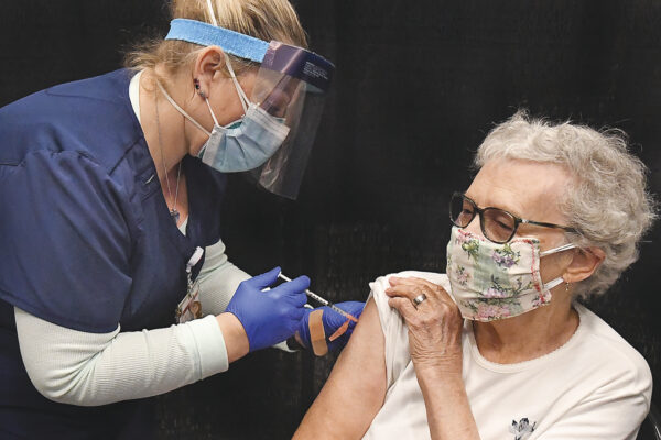 Yuma Regional Medical Center registered nurse Candace Manville, left, administers a COVID-19 vaccine to 94-year-old Edith Robbins at the YRMC vaccination clinic, Thursday, Jan. 28, 2021, inside Yuma Civic Center in Yuma, Ariz. (Randy Hoeft/The Yuma Sun via AP)