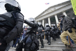 Police in riot gear walk out of the Capitol, Wednesday, Jan. 6, 2021, in Washington. As Congress prepares to affirm President-elect Joe Biden’s victory, thousands of people have gathered to show their support for President Donald Trump and his claims of election fraud. (AP Photo/Manuel Balce Ceneta)