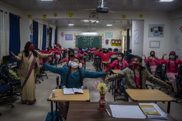 School students gesture a hug as they attend classes as schools reopen after being closed for months due to the COVID-19 pandemic in New Delhi, India, Monday, Jan. 18, 2021. Delhi on Monday opened schools for students of grade 10 and 12 after a gap of more than nine months. (AP Photo/Altaf Qadri) School students gesture a hug as they attend classes as schools reopen after being closed for months due to the COVID-19 pandemic in New Delhi, India, Monday, Jan. 18, 2021. Delhi on Monday opened schools for students of grade 10 and 12 after a gap of more than nine months. (AP Photo/Altaf Qadri)