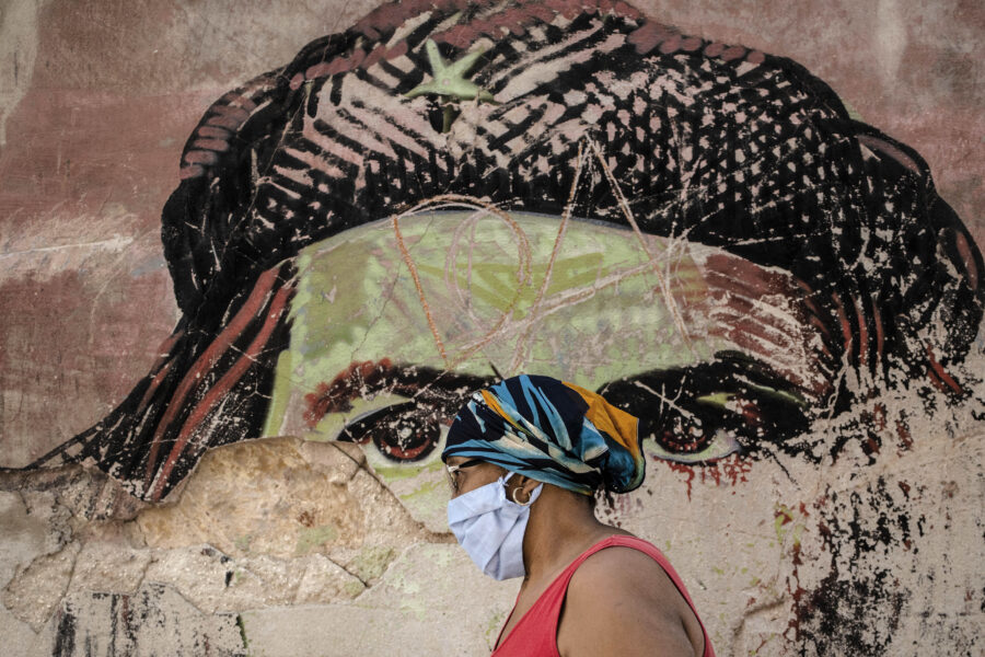 A woman wearing a protective face mask amid the new coronavirus pandemic, walks past a dilapidated mural featuring Argentine-born Cuban revolutionary hero Ernesto “Che” Guevara, in Old Havana, Cuba, Tuesday, Jan. 19, 2021. ( AP Photo/Ramon Espinosa)