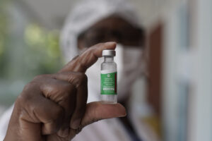 A health worker shows a vial of the Oxford-AstraZeneca vaccine for COVID-19 being used during a priority vaccination program for the elderly at a vaccination center in Rio de Janeiro, Brazil, Monday, Feb. 1, 2021. (AP Photo/Silvia Izquierdo)