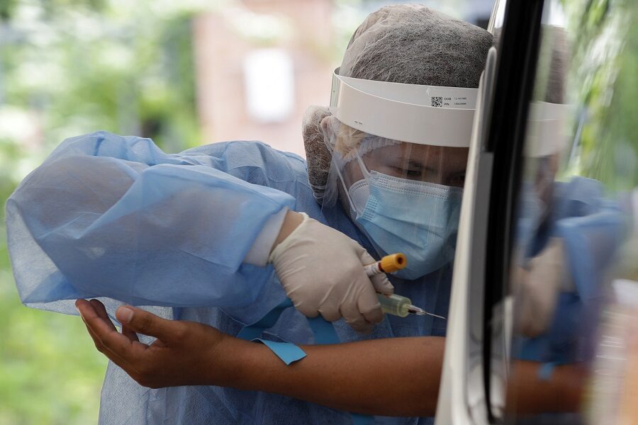 A health worker takes blood to perform an Enhanced Chemiluminescence Immunoassay (ECLIA) antibody test at a drive-thru COVID-19 testing facility at a hospital in metropolitan Manila, Philippines on Wednesday, July 8, 2020. Philippine President Rodrigo Duterte eased one of the world’s longest lockdowns in the Philippine capital of more than 13 million people on June 1 after the economy shrank in the first quarter in its first contraction in more than two decades. (AP Photo/Aaron Favila)