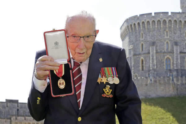 FILE – In this Friday, July 17, 2020 file photo, Captain Sir Thomas Moore poses for the media after receiving his knighthood from Britain’s Queen Elizabeth, during a ceremony at Windsor Castle in Windsor, England. Tom Moore, the 100-year-old World War II veteran who captivated the British public in the early days of the coronavirus pandemic with his fundraising efforts, has been admitted to a hospital with COVID-19, his daughter said Sunday Jan. 31, 2021. (Chris Jackson/Pool Photo via AP, File)