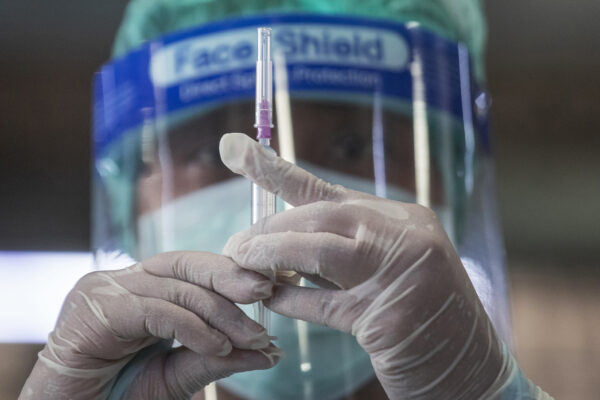 A health worker prepares a dose of the Sinovac COVID-19 vaccine for people who live in a popular market area where a new cluster of Covid 19 infections was found in Bangkok, Thailand, Wednesday, March 17, 2021. Thai authorities set up units for to administer the COVID-19 vaccines at the Bangkhae market where a new cluster of over a hundred cases was confirmed over the weekend. (AP Photo/Sakchai Lalit)