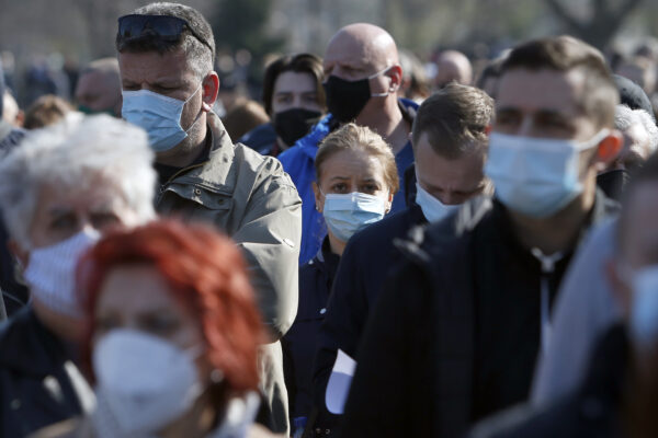 People wait in line to receive a dose of the AstraZeneca vaccine at Belgrade Fair makeshift vaccination center in Belgrade, Serbia, Saturday, March 27, 2021. Thousands of vaccine-seekers from Serbia’s neighboring states have flocked to Belgrade after Serbian authorities offered free coronavirus jabs for foreigners if they show up over the weekend. Many arriving with their entire families, long lines of Bosnians, Montenegrins, North Macedonians and even Albanians formed Saturday in front of the main vaccination center in the Serbian capital. (AP Photo/Darko Vojinovic)