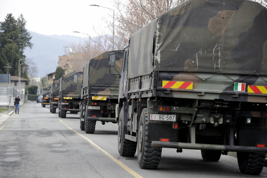 FILE – In this March 26, 2020 file photo, military trucks moving coffins of deceased people leave the cemetery of Bergamo, one of the areas worst hit by the coronavirus infection, on their way to a crematory in some other location as the local crematory exceeded its maximum capacity. Italy marked the anniversary of one of the most haunting moments of its COVID-19 emergency, when Bergamo’s death toll reached such heights that an army convoy had to transport the dead out because its cemeteries and crematoria were full. (AP Photo/Luca Bruno)