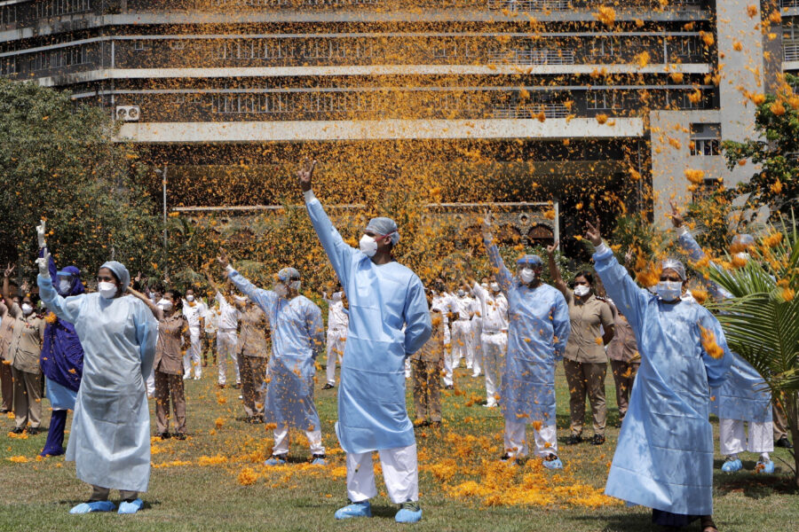 FILE – In this May 3, 2020, file photo, an Indian Air Force helicopter showers flower petals on the staff of INS Asvini hospital in Mumbai, India. The event was part the Armed Forces’ efforts to thank the workers, including doctors, nurses and police personnel, who have been at the forefront of the country’s battle against the COVID-19 pandemic. India’s death toll from COVID-19 has surpassed 200,000 as a virus surge sweeps the country, rooted in so-called super-spreader events that were allowed to happen in the months following the autumn when  the country had seemingly brought the pandemic under control. (AP Photo/Rajanish Kakade, File)