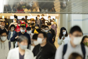 People wearing face masks walk between train stations for transit in the famed Namba district of Osaka, western Japan, Saturday, April 17, 2021. (AP Photo/Hiro Komae)