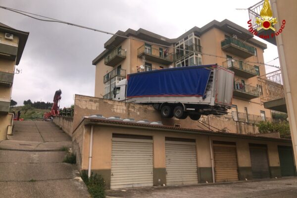 Camion ‘sospeso’ sul tetto rischia di cadere su una palazzina: evacuati i residenti