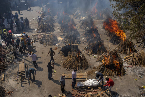 FILE – In this April 24, 2021, file photo, multiple funeral pyres of victims of COVID-19 burn at a ground that has been converted into a crematorium for mass cremation in New Delhi, India. India’s death toll from COVID-19 has surpassed 200,000 as a virus surge sweeps the country, rooted in so-called super-spreader events that were allowed to happen in the months following the autumn when  the country had seemingly brought the pandemic under control. (AP Photo/Altaf Qadri, File)