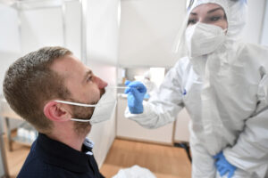 An employee in protective clothing takes a swab from a man in the Corona test centre at the trade fair in Erfurt, Germany, Wednesday, April 28, 2021. The rapid test centre is operated primarily for visitors to the Federal Horticultural Show in exhibition hall three of the fair grounds. (Martin Schutt/dpa via AP) An employee in protective clothing takes a swab from a man in the Corona test centre at the trade fair in Erfurt, Germany, Wednesday, April 28, 2021. The rapid test centre is operated primarily for visitors to the Federal Horticultural Show in exhibition hall three of the fair grounds. (Martin Schutt/dpa via AP)