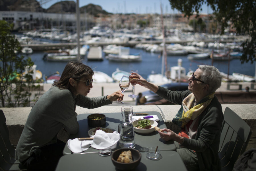 Charlotte Barrau and her mother Dany Barrau share a toast on a restaurant terrace, in La Ciotat southern France, Wednesday, May 19, 2021. Cafe and restaurant terraces reopened Wednesday after a pandemic shutdown of more than six months deprived people of what feels like the essence of life in France. The French government is lifting restrictions incrementally to stave off a resurgence of COVID-19 and to give citizens back some of their signature “joie de vivre.”(AP Photo/Daniel Cole)