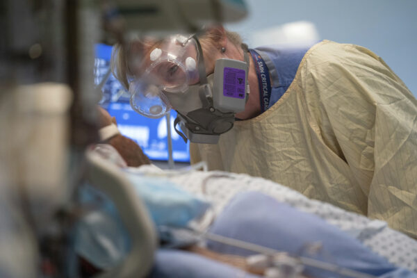 Registered nurse Linda Wright speaks to a patient in the COVID-19 Intensive Care Unit at Surrey Memorial Hospital in Surrey, British Columbia, Friday, June 4, 2021. (Jonathan Hayward/The Canadian Press via AP)