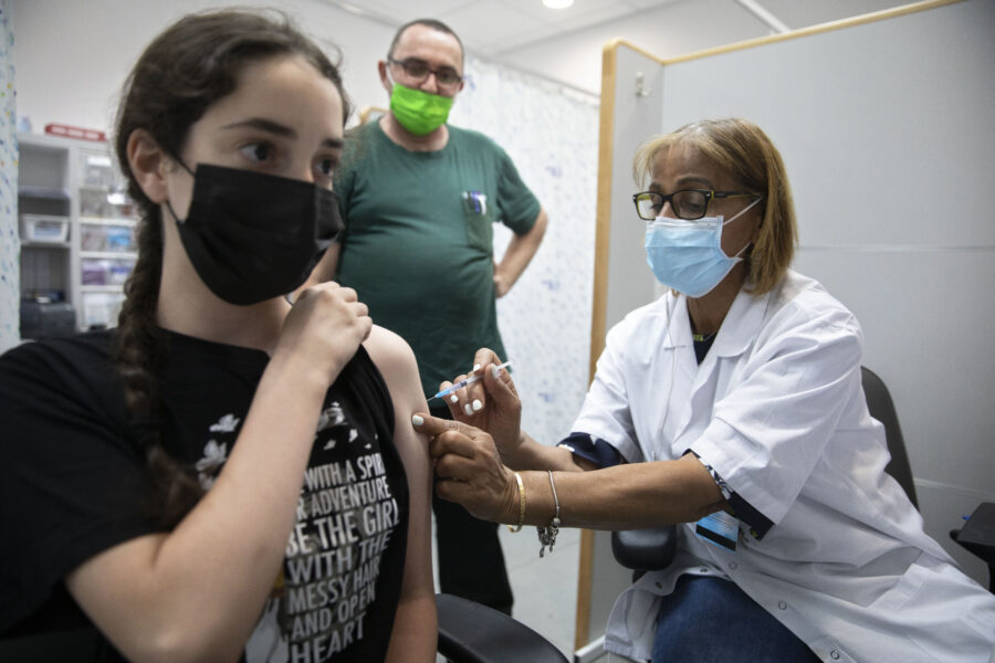 An Israeli youth receives a Pfizer-BioNTech COVID-19 vaccine in the central Israeli city of Rishon LeZion, Sunday, June 6, 2021. Israel started vaccinating children from 12 to 15 on Sunday. (AP Photo/Sebastian Scheiner)