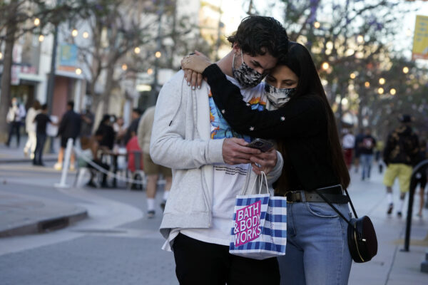 Shoppers embrace and wear masks amid the COVID-19 pandemic on The Promenade Wednesday, June 9, 2021, in Santa Monica, Calif. (AP Photo/Marcio Jose Sanchez)