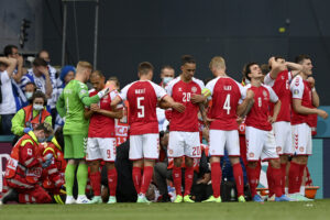 Denmark players make a wall around teammate Christian Eriksen being assisted by medics during the Euro 2020 soccer championship group B match between Denmark and Finland at Parken Stadium in Copenhagen, Saturday, June 12, 2021. (Stuart Franklin/Pool via AP)
