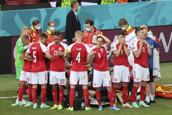 Denmark’s players react as their teammate Christian Eriksen lays on the ground during the Euro 2020 soccer championship group B match between Denmark and Finland at Parken stadium in Copenhagen, Denmark, Saturday, June 12, 2021. (Wolfgang Rattay/Pool via AP)