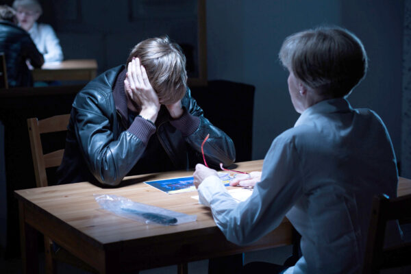 43836317 – young offender covering ears during police interrogation