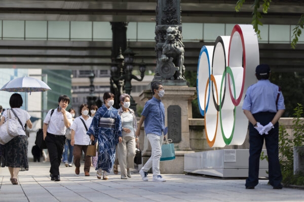 People walk by the Olympic rings installed by the Nippon Bashi bridge in Tokyo on Thursday, July 15, 2021. (AP Photo/Hiro Komae)