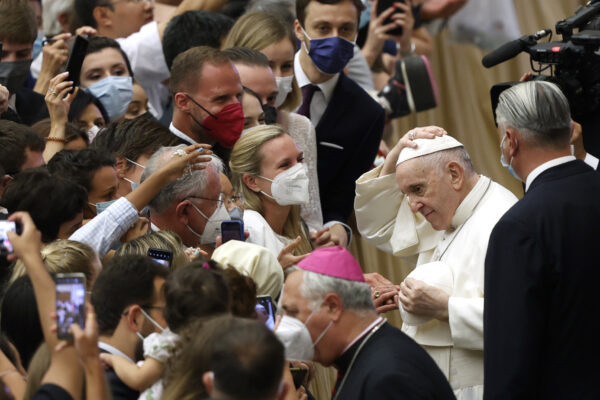 Pope Francis exchanges his skull cap with another one he was given by faithful at the end of his weekly general audience in the Paul VI hall at the Vatican, Wednesday, Aug. 4, 2021. Pope Francis on Wednesday resumed his routine of weekly audiences with the general public a month after he underwent bowel surgery, expressing his desire to visit someday Lebanon, as he recalled the first anniversary of the devastating Beirut port explosion. (AP Photo/Riccardo De Luca)