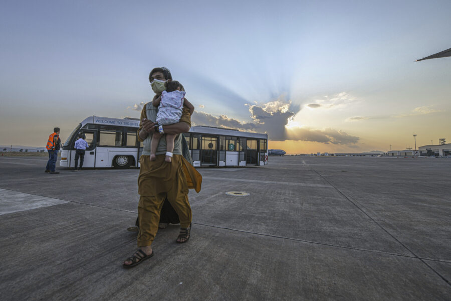 In this image provided by the U.S. Navy, evacuees from Afghanistan board a flight bound for the United States from Naval Air Station Sigonella, Italy, Sunday, Aug. 28, 2021.  U.S.-bound planes flew Sunday to Philadelphia and Washington, D.C. carrying U.S. citizens and Afghan nationals evacuated from the chaos in Afghanistan. A joint statement from the Naval Air Station in Sigonella and the U.S. Embassy in Rome did not specify how many flights nor how many passengers departed on the first flights from the U.S. base, saying only that the flights departed at full capacity. (MC2 Kaila V. Peters/U.S. Navy via AP)