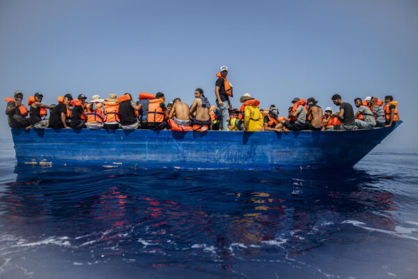 A group thought to be migrants from Tunisia aboard a precarious wooden boat waiting to be assisted by a team of the Spanish NGO Open Arms, around 20 miles southwest from the Italian island of Lampedusa, in Italian SAR zone, Thursday July 29, 2021.  The NGO assisted more than 170 people who arrived next to the Italian island on board six different wooden dinghies, before the Italian authorities took them to land. (AP Photo/Santi Palacios)