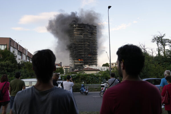 Smoke billows from a building in Milan, Italy, Sunday, Aug. 29, 2021. Firefighters were battling a blaze on Sunday that spread rapidly through a recently restructured 60-meter-high, 16-story residential building in Milan. There were no immediate reports of injuries or deaths. (AP Photo/Luca Bruno)