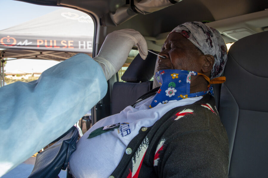 FILE — In this May 22, 2020, file photo, an elderly woman reacts as a heath worker collects a sample to test for COVID-19 in Katlehong, Johannesburg, South Africa. South Africa’s reported coronavirus are surging. Its hospitals are now bracing for an onslaught of patients, setting up temporary wards and hoping advances in treatment will help the country’s health facilities from becoming overwhelmed. (AP Photo/Themba Hadebe, File)