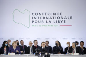 French President Emmanuel Macron, center , German Chancellor Angela Merkel, left, and Italian Prime Minister Mario Draghi attend a conference on Libya in Paris Friday, Nov. 12, 2021. France is hosting an international conference on Libya on Friday as the North African country is heading into long-awaited elections next month. (Yoan Valat/Pool Photo via AP)