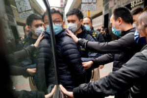 Editor of Stand News’ Patrick Lam, center, is escorted by police officers into a van after they searched evidence at his office in Hong Kong, Wednesday, Dec. 29, 2021. Hong Kong police raided the office of the online news outlet on Wednesday after arresting several people for conspiracy to publish a seditious publication. (AP Photo/Vincent Yu)