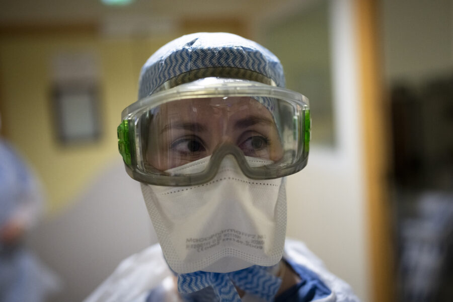 Radiographer Coralie Gil prepares to enter the room of a COVID-19 patient in the COVID-19 continued care unit at the la Timone hospital in Marseille, southern France, Friday, Dec. 24, 2021. (AP Photo/Daniel Cole)