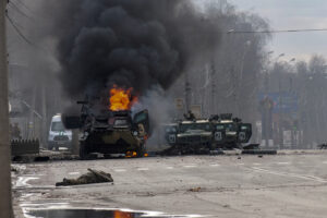 An armored personnel carrier burns and damaged light utility vehicles stand abandoned after fighting in Kharkiv, Ukraine, Sunday, Feb. 27, 2022. The city authorities said that Ukrainian forces engaged in fighting with Russian troops that entered the country’s second-largest city on Sunday. (AP Photo/Marienko Andrew)