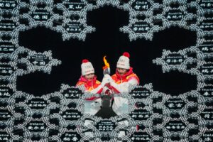 Olimpiadi invernali, la propaganda del regime di Pechino: il braciere acceso da un’atleta uigura