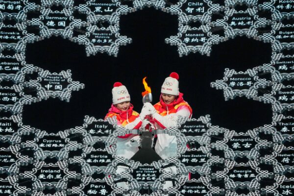 Olimpiadi invernali, la propaganda del regime di Pechino: il braciere acceso da un’atleta uigura