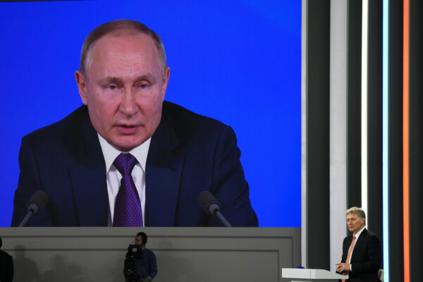 Kremlin spokesman Dmitry Peskov, right, listens to Russian President Vladimir Putin speaking during his annual news conference in Moscow, Russia, Thursday, Dec. 23, 2021. (AP Photo/Alexander Zemlianichenko)