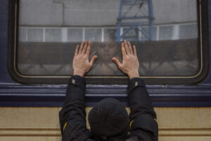 Aleksander, 41, presses his palms against the window as he says goodbye to his daughter Anna, 5, on a train to Lviv at the Kyiv station, Ukraine, Friday, March 4. 2022. Aleksander has to stay behind to fight in the war while his family leaves the country to seek refuge in a neighboring country. (AP Photo/Emilio Morenatti)