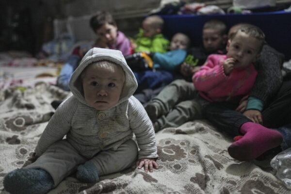 Children pose for a photographer in the bomb shelter in Mariupol, Ukraine, Sunday, March 6, 2022. (AP Photo/Evgeniy Maloletka)