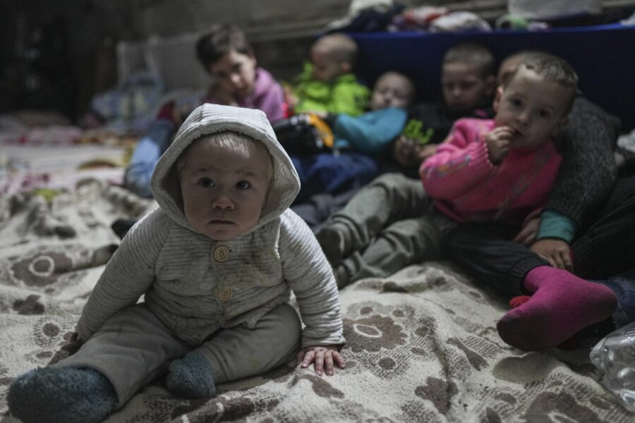 Children pose for a photographer in the bomb shelter in Mariupol, Ukraine, Sunday, March 6, 2022. (AP Photo/Evgeniy Maloletka)