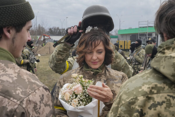 A soldier holds a helmet as a wedding crown during the wedding ceremony for members of the Ukrainian Territorial Defence Forces Lesia Ivashchenko and Valerii Fylymonov, at a checkpoint in Kyiv, Ukraine, Sunday, March 6, 2022. (AP Photo/Efrem Lukatsky)